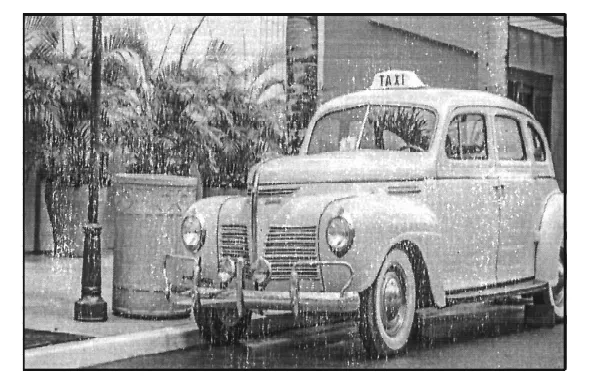 A grey photograph of an old taxi parked at a kerb beside a palm tree.